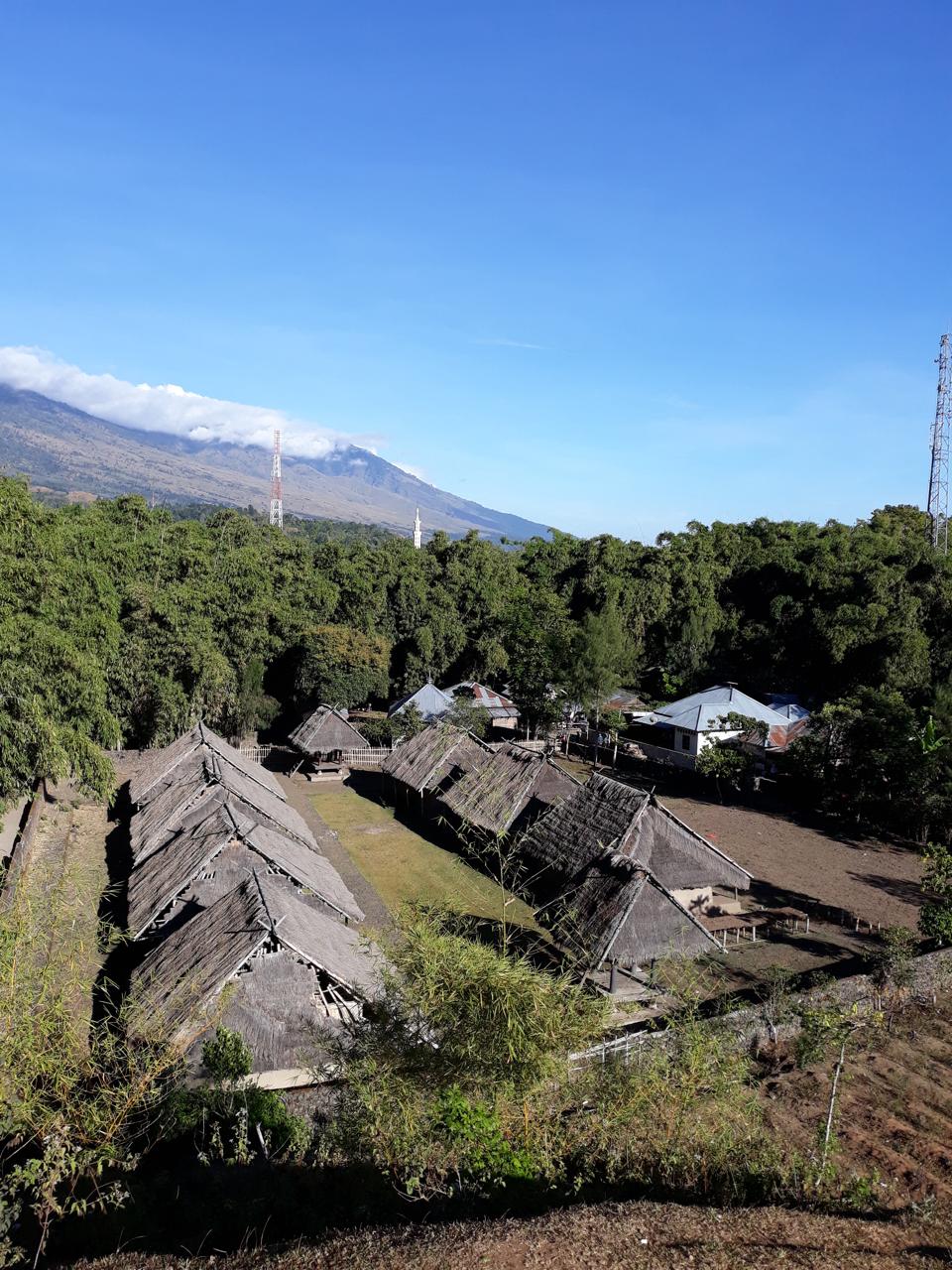 traditional Sasak village in Lombok with thatched-roof houses and local women weaving handwoven fabrics.