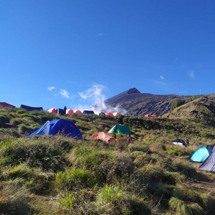 Sembalun campsite on Mount Rinjani with colorful trekking tents surrounded by mountain landscapes and sunrise views